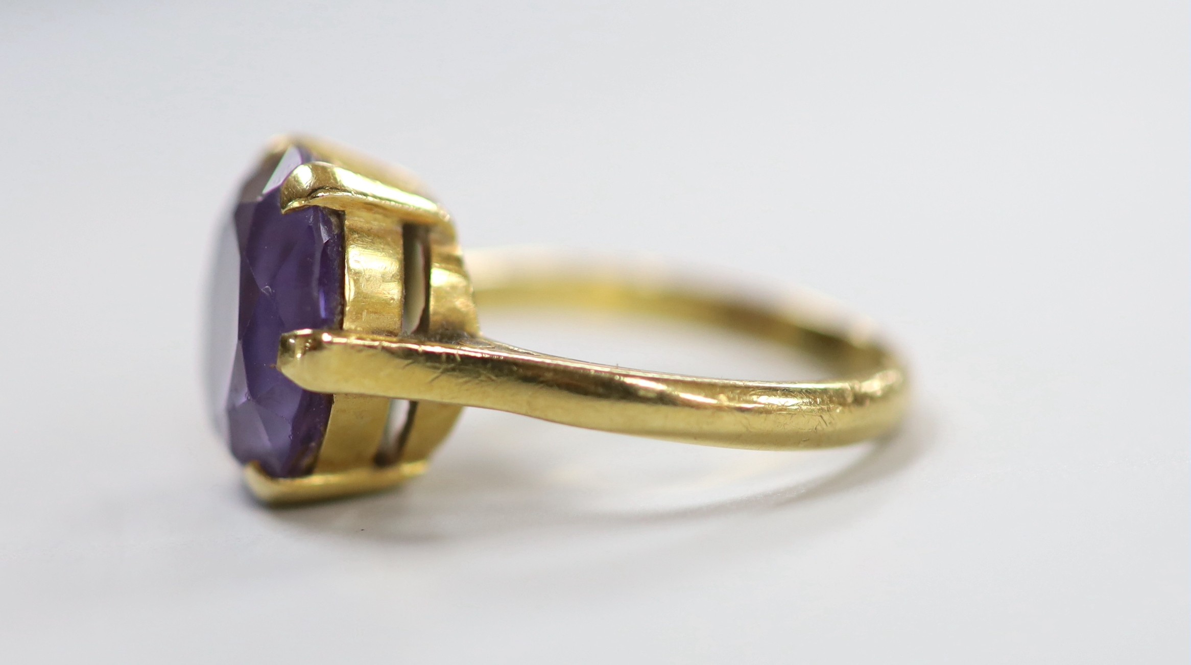 An 18ct and synthetic colour change corundum set dress ring, size O, gross weight 6.5 grams.